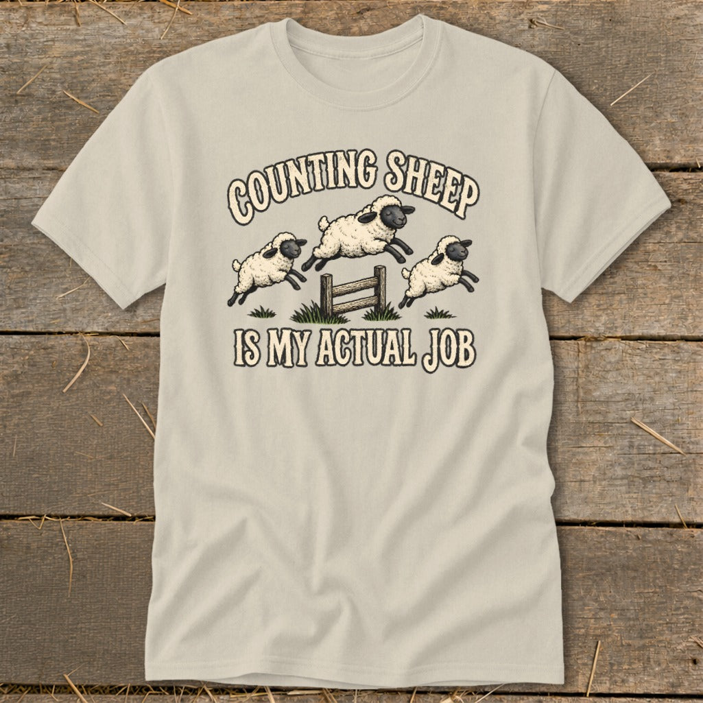 T-shirt with three sheep jumping over a fence and the text "Counting Sheep Is My Actual Job."