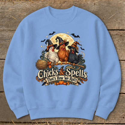 Three chickens in witch hats ride a broomstick under a moon, with text "Chicks & Spells That's How We Roll!".