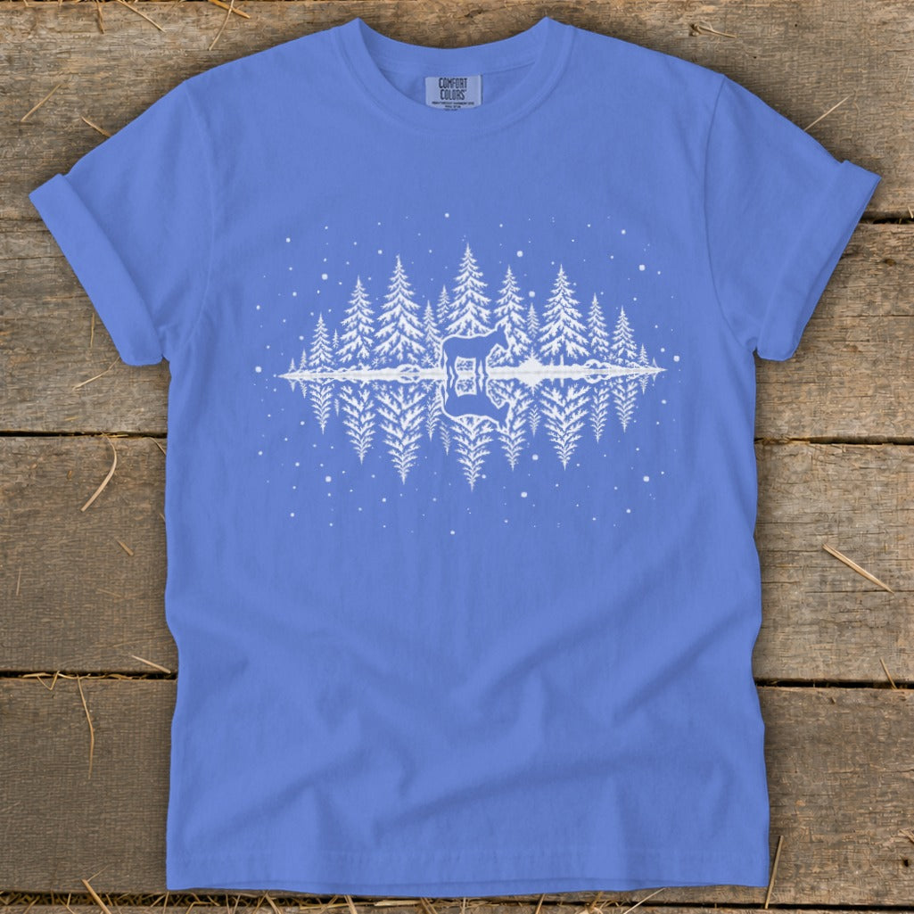 Blue t-shirt with white graphic of pine trees, deer silhouette, and reflection.