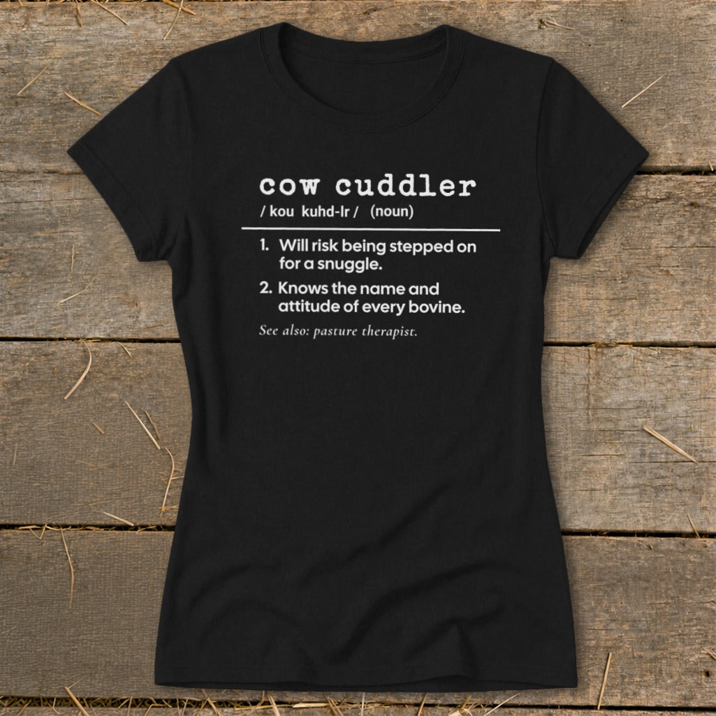 Black t-shirt with white text defining "cow cuddler" and its associated characteristics.
