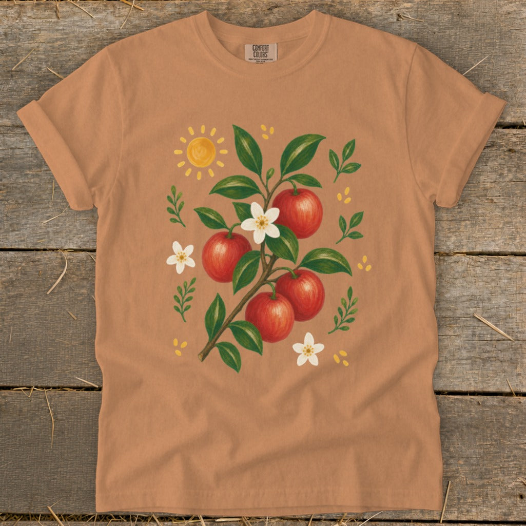 T-shirt with a branch of red apples and white blossoms, sun, and leaves.