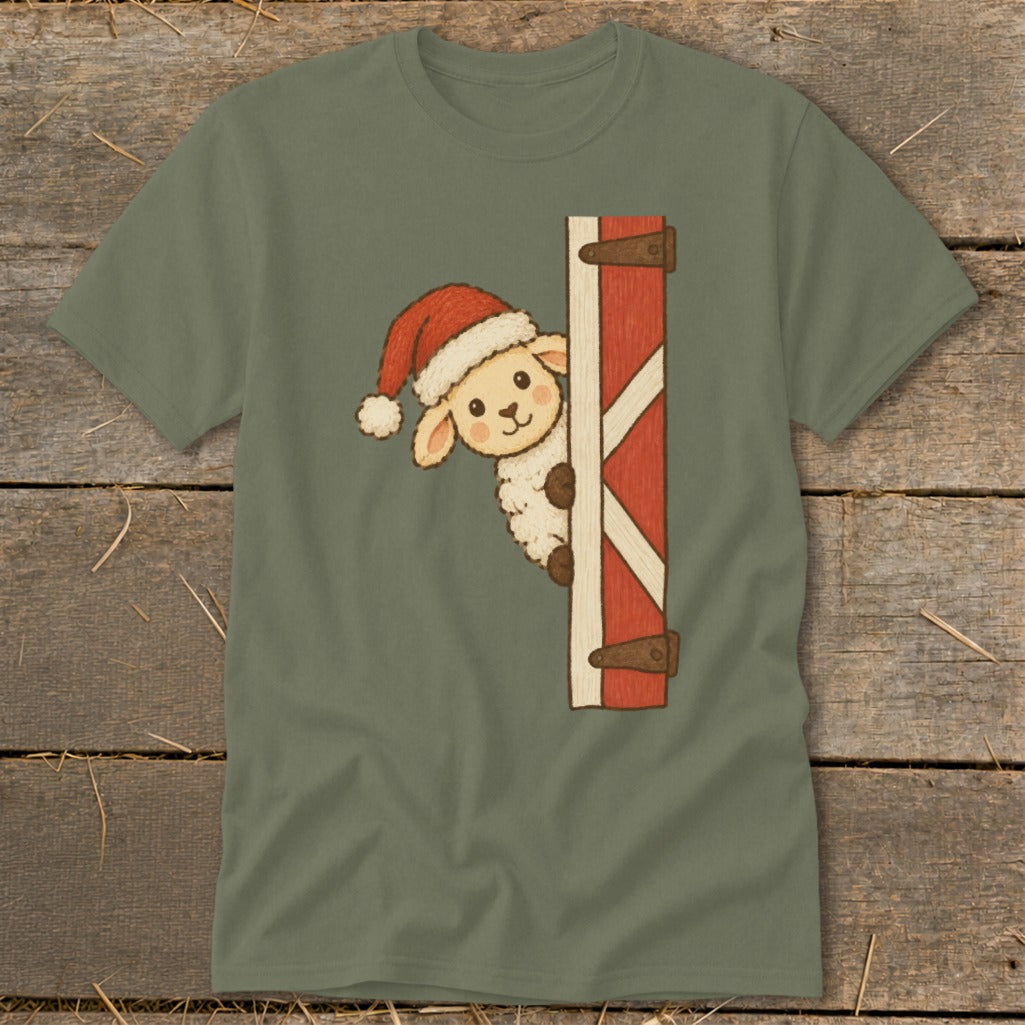 Sheep wearing Santa hat peeking from behind barn door on green t-shirt.