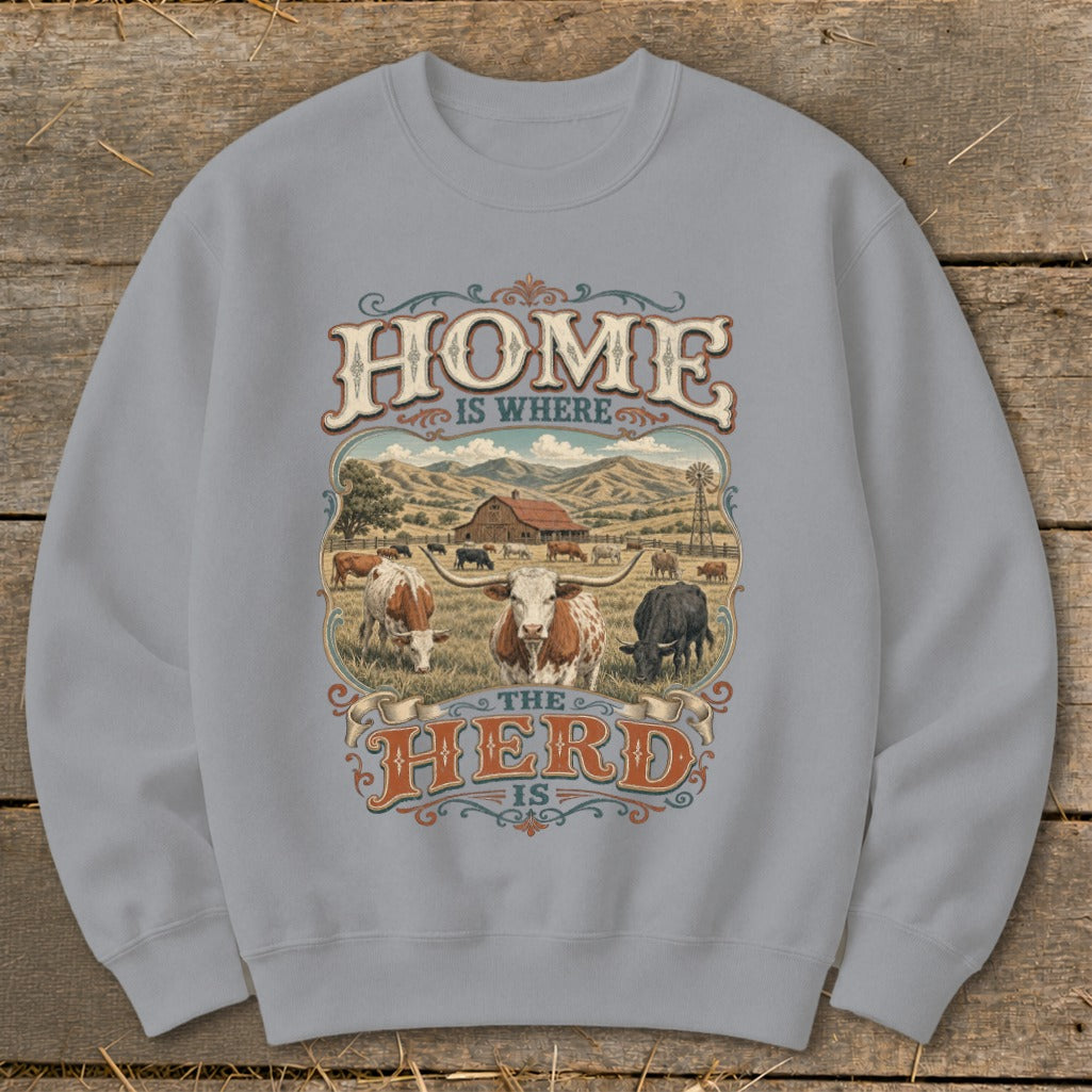 Sweatshirt with "Home is Where the Herd Is" text and farm scene with cattle.