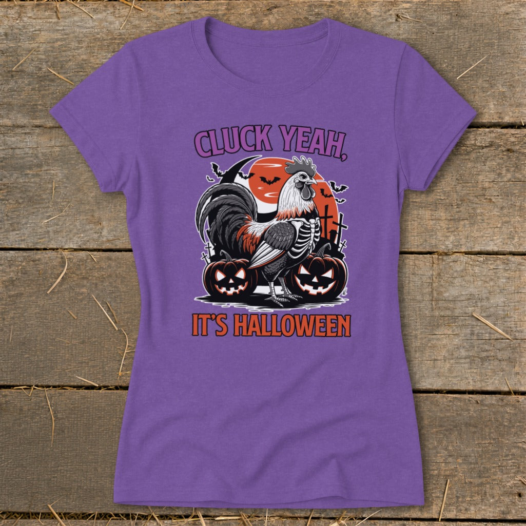 Purple t-shirt with skeleton rooster, pumpkins, moon, and text "Cluck Yeah, It's Halloween".