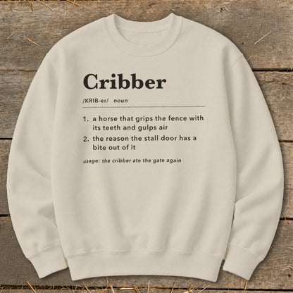 Beige crewneck sweatshirt featuring a dictionary-style definition of the word cribber printed in black text.