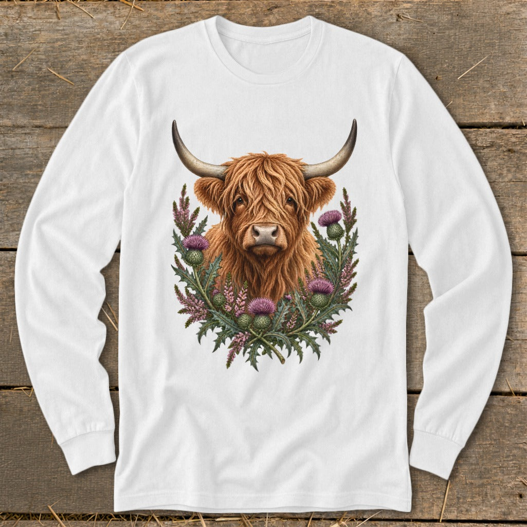 Highland cow portrait surrounded by thistles and wildflowers on a white long-sleeve shirt.