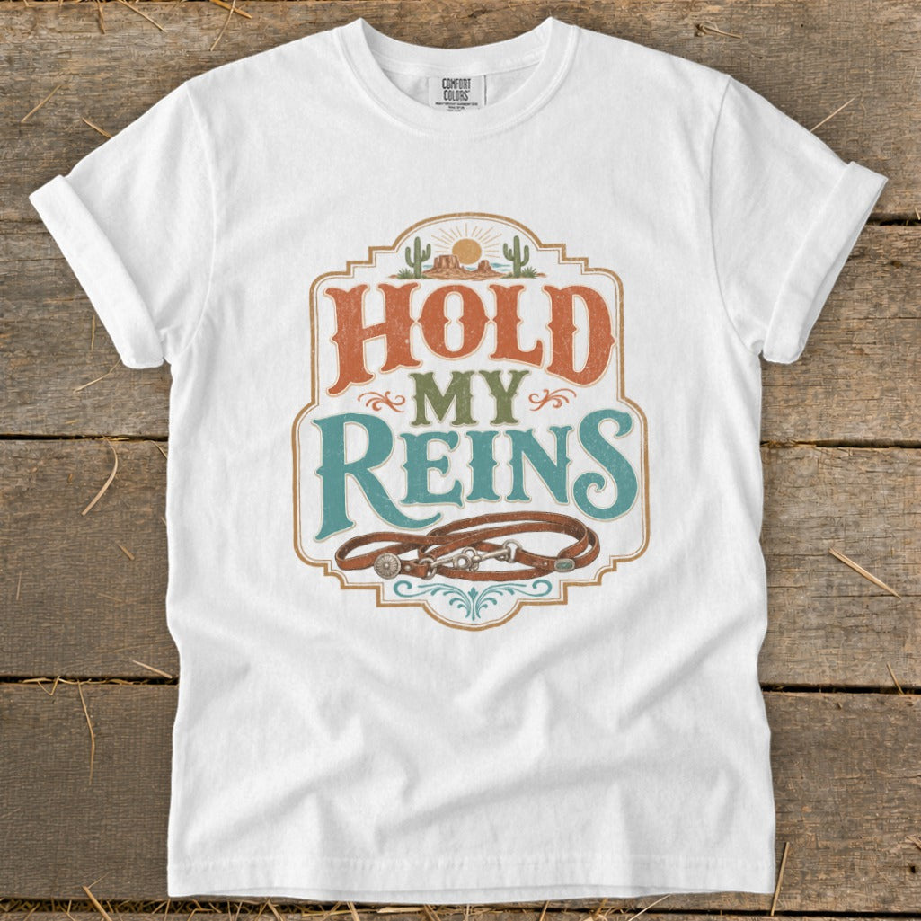 White t-shirt with "HOLD MY REINS" text and a horse bridle graphic.