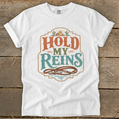 White t-shirt with "HOLD MY REINS" text and a horse bridle graphic.