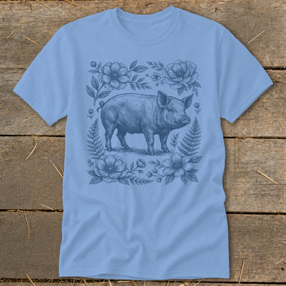 Light blue t-shirt with a vintage sketch of a pig surrounded by flowers and ferns.