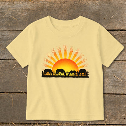 Yellow t-shirt with black silhouette of horses grazing at sunrise.