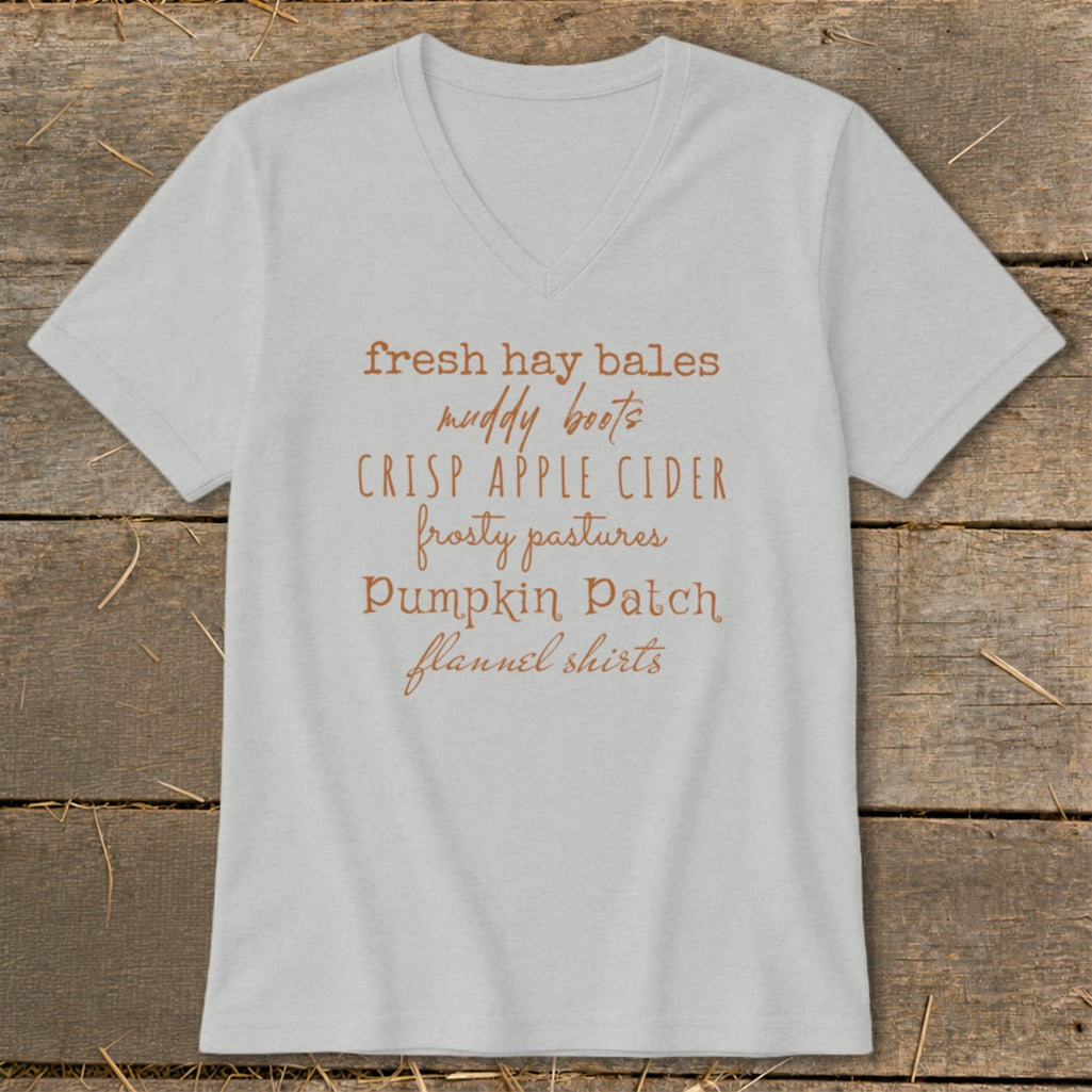 Light grey v-neck t-shirt with text: fresh hay bales, muddy boots, crisp apple cider, frosty pastures, pumpkin patch, flannel shirts.