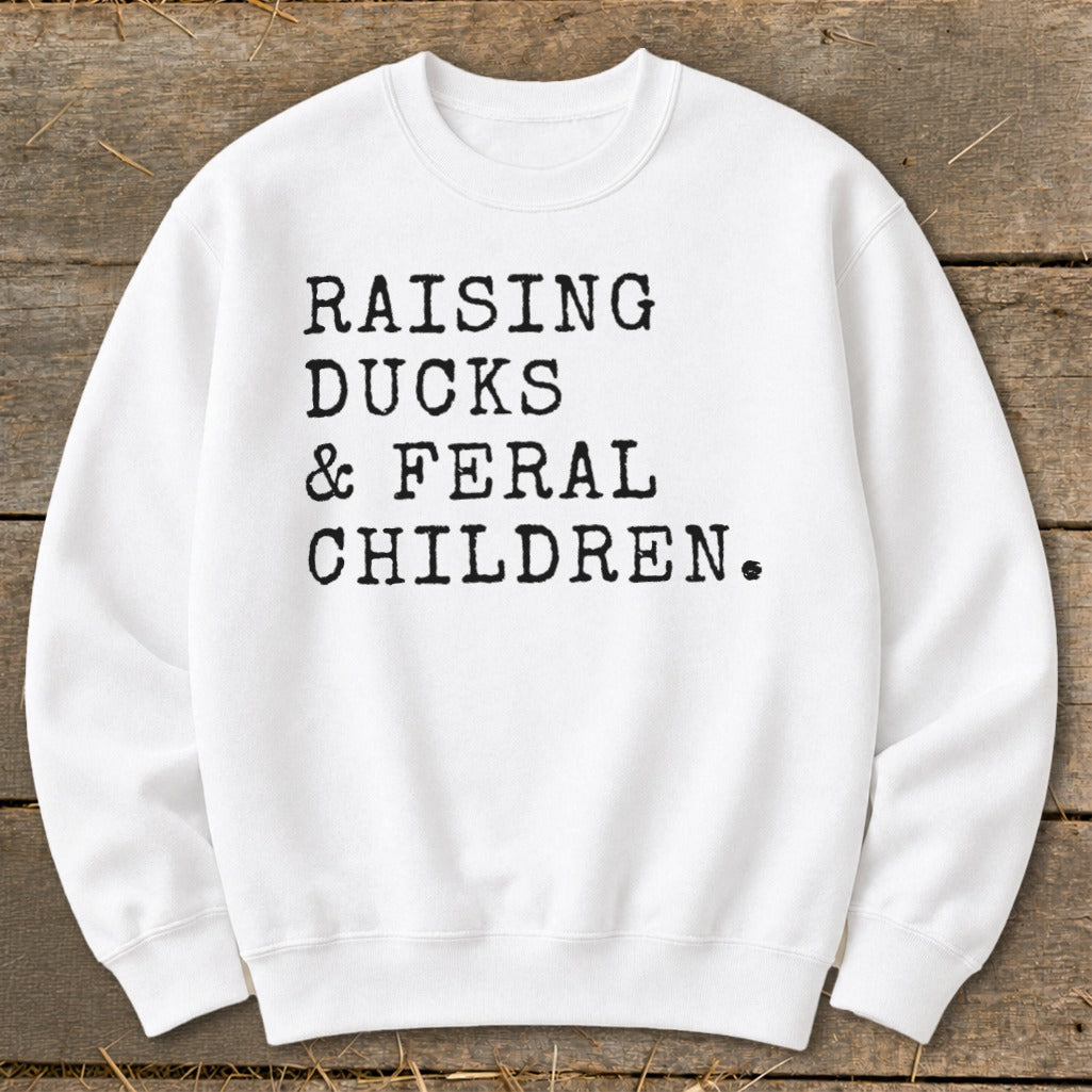 White sweatshirt with black text: "RAISING DUCKS & FERAL CHILDREN."