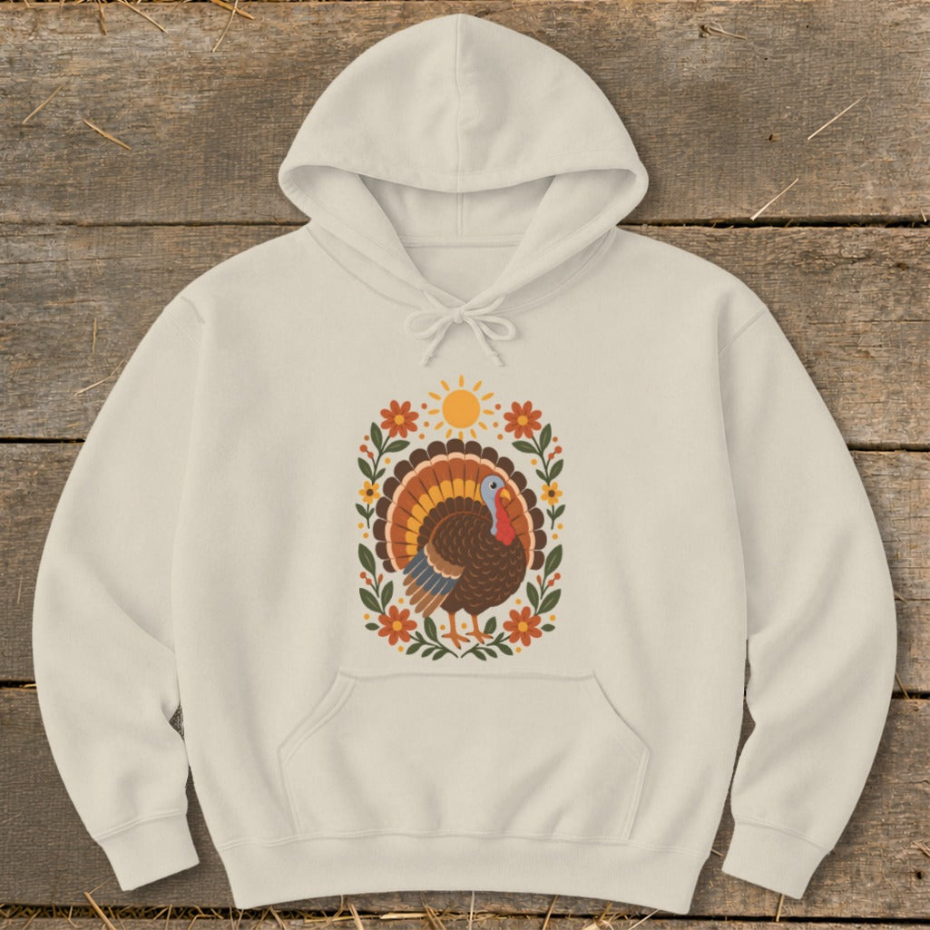 Cream hoodie with a decorative turkey, sun, and floral design.