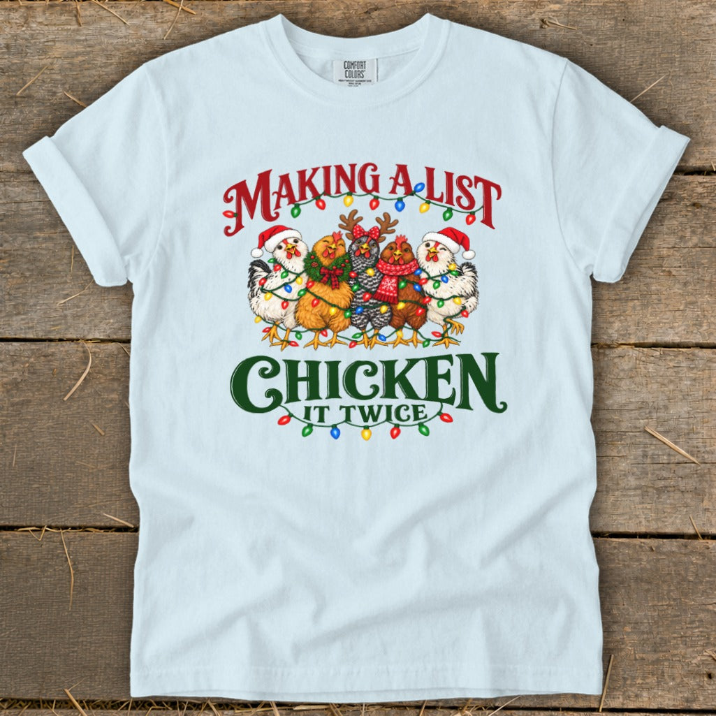 Light blue t-shirt with chickens wearing Santa hats and Christmas lights, reading "Making a List, Chicken It Twice".