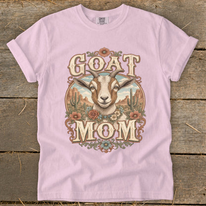 Pink t-shirt with "GOAT MOM" text and a goat illustration in a desert landscape.