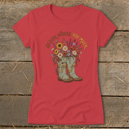 Red t-shirt with graphic of boots overflowing with flowers, and text "Bloom Where You Muck".