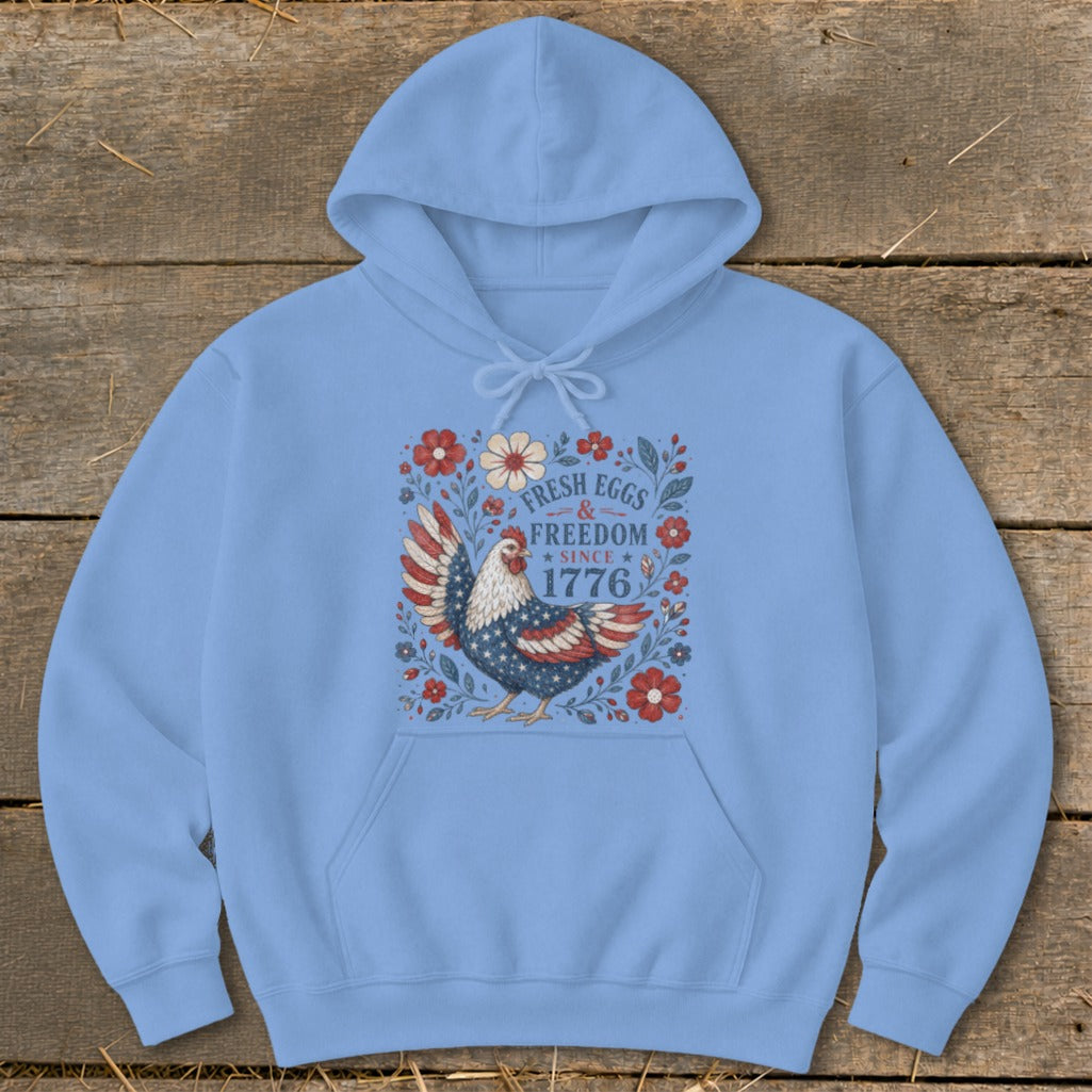 Light blue hoodie with a patriotic chicken graphic and text "Fresh Eggs & Freedom Since 1776".