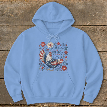 Light blue hoodie with a patriotic chicken graphic and text "Fresh Eggs & Freedom Since 1776".