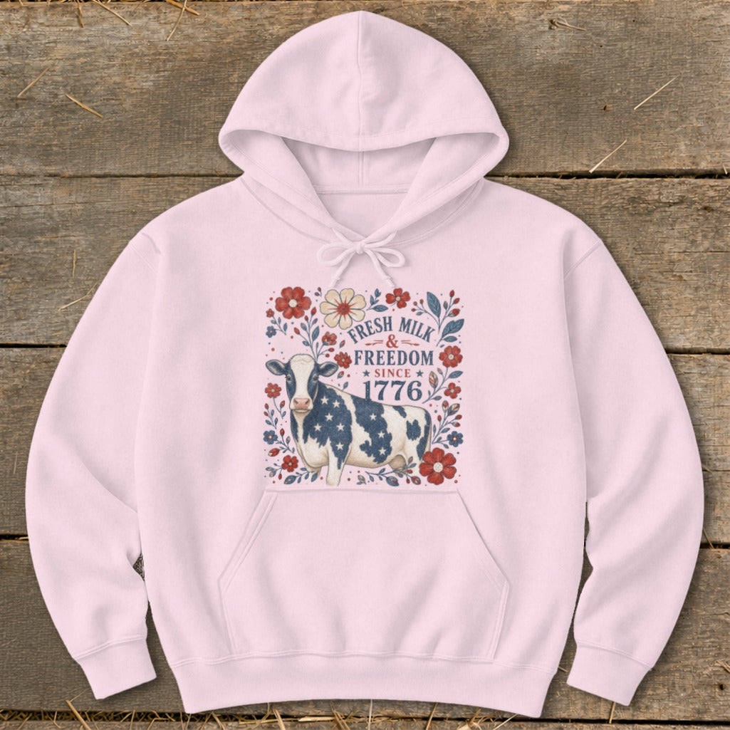 Pink hoodie with a cow design featuring "Fresh Milk & Freedom Since 1776".
