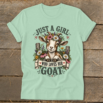 Light mint t-shirt with a graphic of a goat wearing flowers, text reads "Just a Girl Who Loves Her Goat".