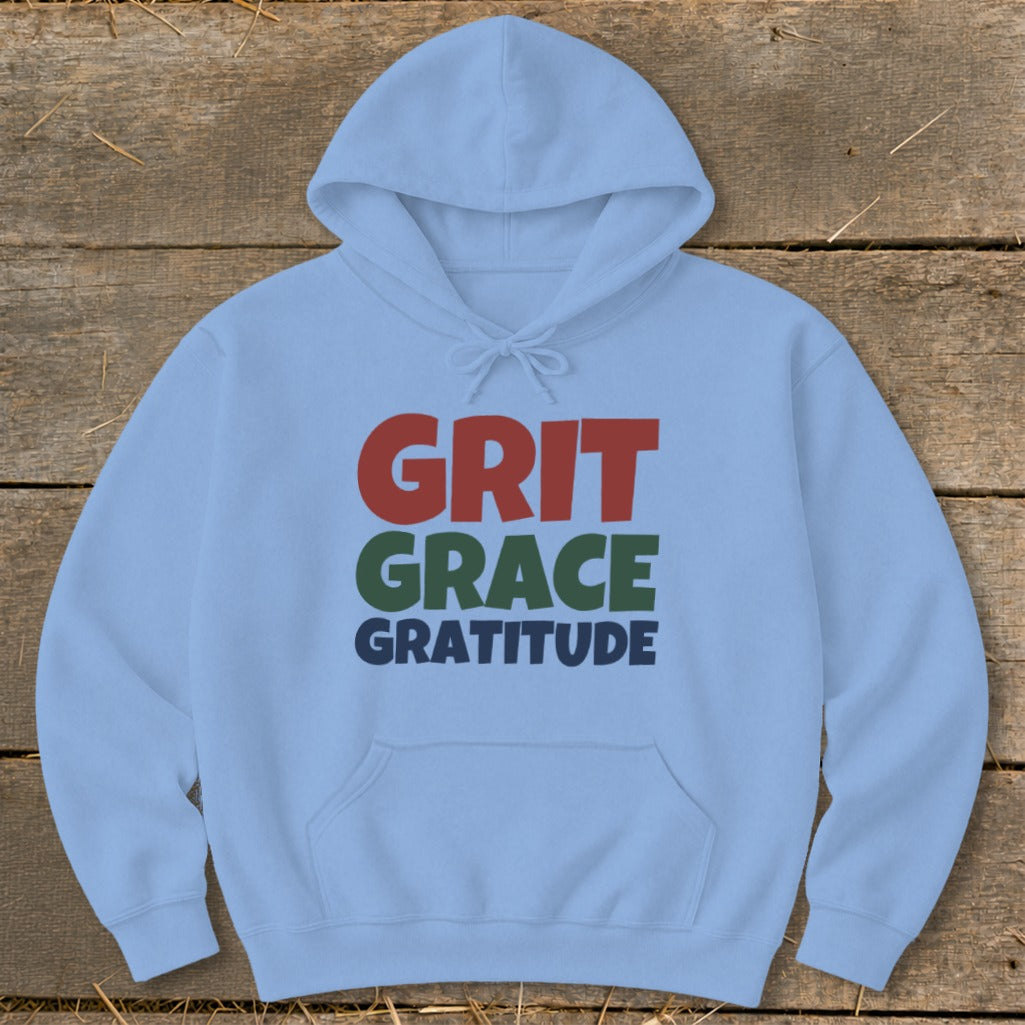 A light blue hooded sweatshirt featuring the words GRIT GRACE GRATITUDE printed on the chest.