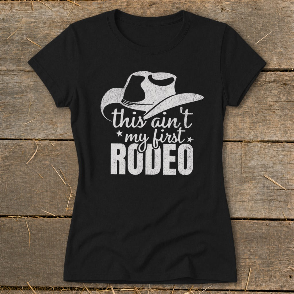 Black t-shirt with distressed white graphic: cowboy hat, "this ain't my first rodeo" text.