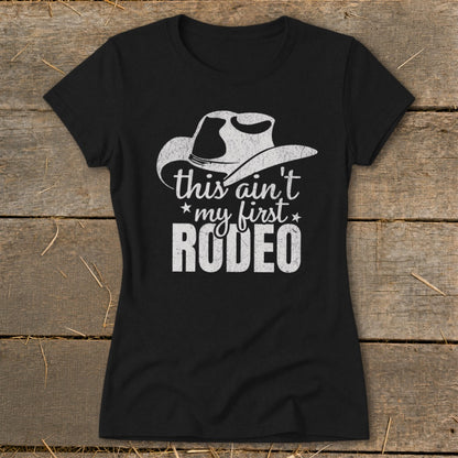 Black t-shirt with distressed white graphic: cowboy hat, "this ain't my first rodeo" text.