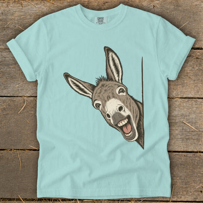 Light blue t-shirt with a cartoon donkey peeking from the side with a wide smile.