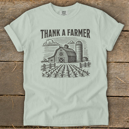 Light blue t-shirt with "Thank a Farmer" text and barn sketch.