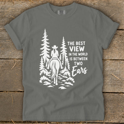 A grey t-shirt featuring a white graphic of a horseback rider in the woods with text.