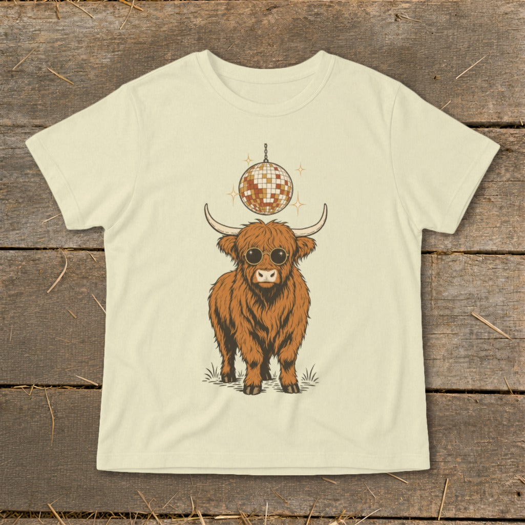 Highland cow wearing sunglasses under a disco ball on a light yellow t-shirt.