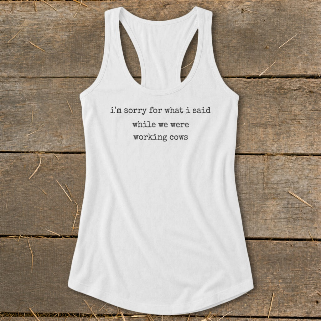 White tank top with black text reading "i'm sorry for what i said while we were working cows".