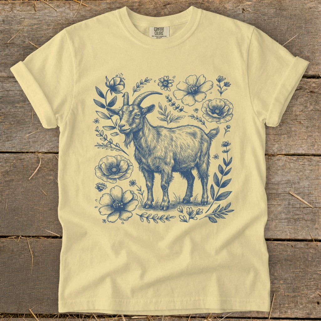 Yellow t-shirt with a navy blue drawing of a goat surrounded by flowers and leaves.