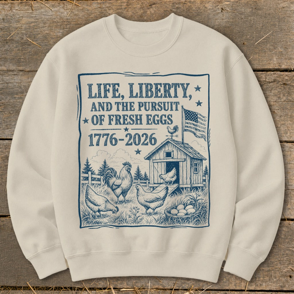Sweatshirt with "Life, Liberty, and the Pursuit of Fresh Eggs 1776-2026" and farm scene.