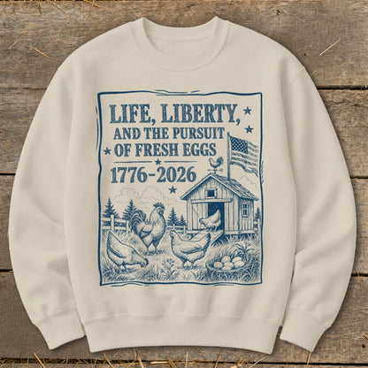 Sweatshirt with "Life, Liberty, and the Pursuit of Fresh Eggs 1776-2026" and farm scene.