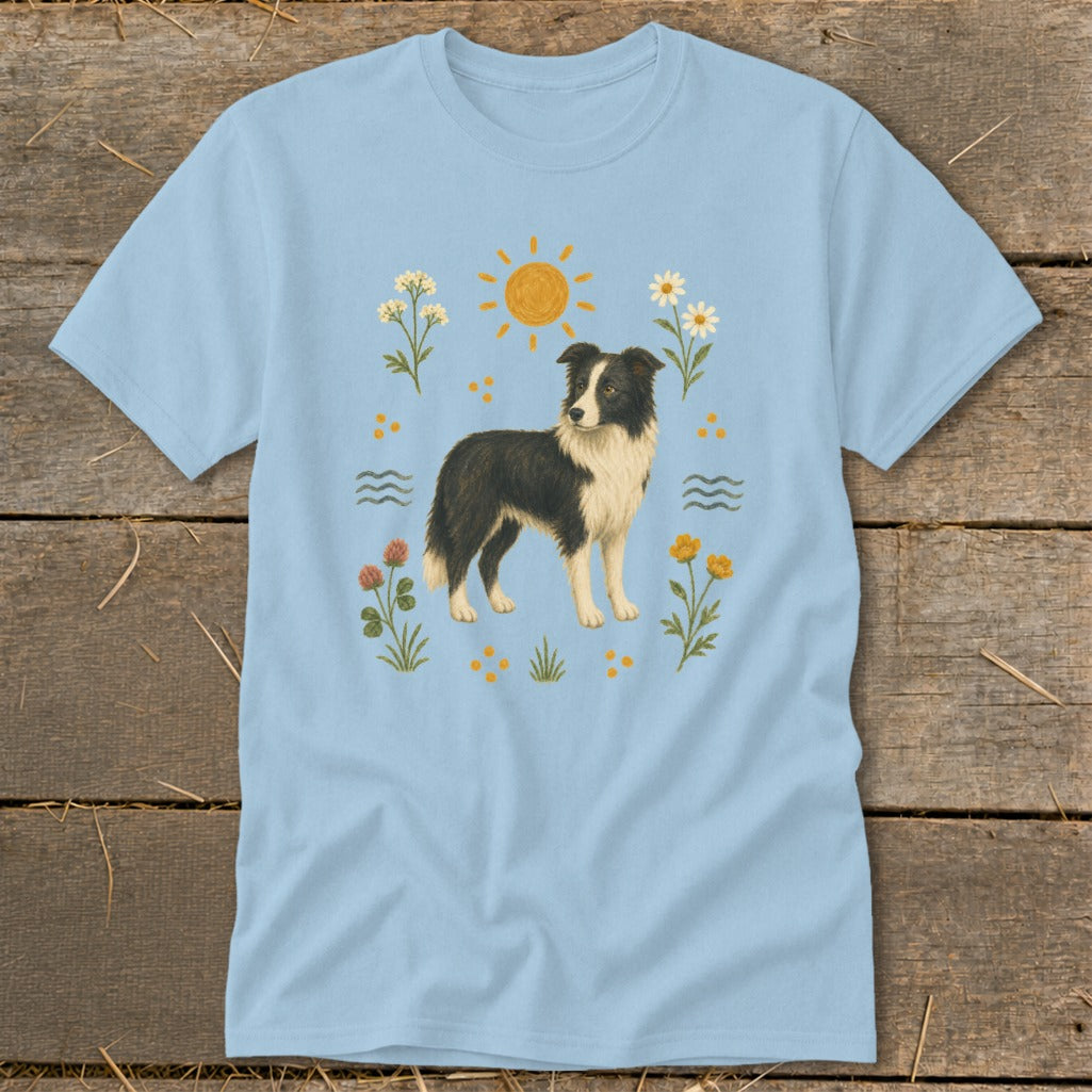Light blue t-shirt with a standing Border Collie dog surrounded by sun, flowers, and waves.