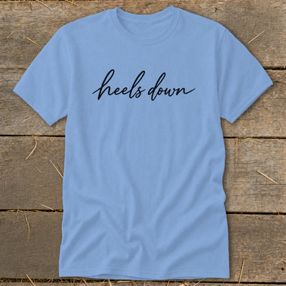 Light blue t-shirt with black cursive text "heels down"