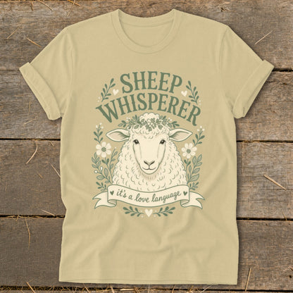 Sheep Whisperer graphic t-shirt with sheep, flowers, and banner saying "it's a love language."