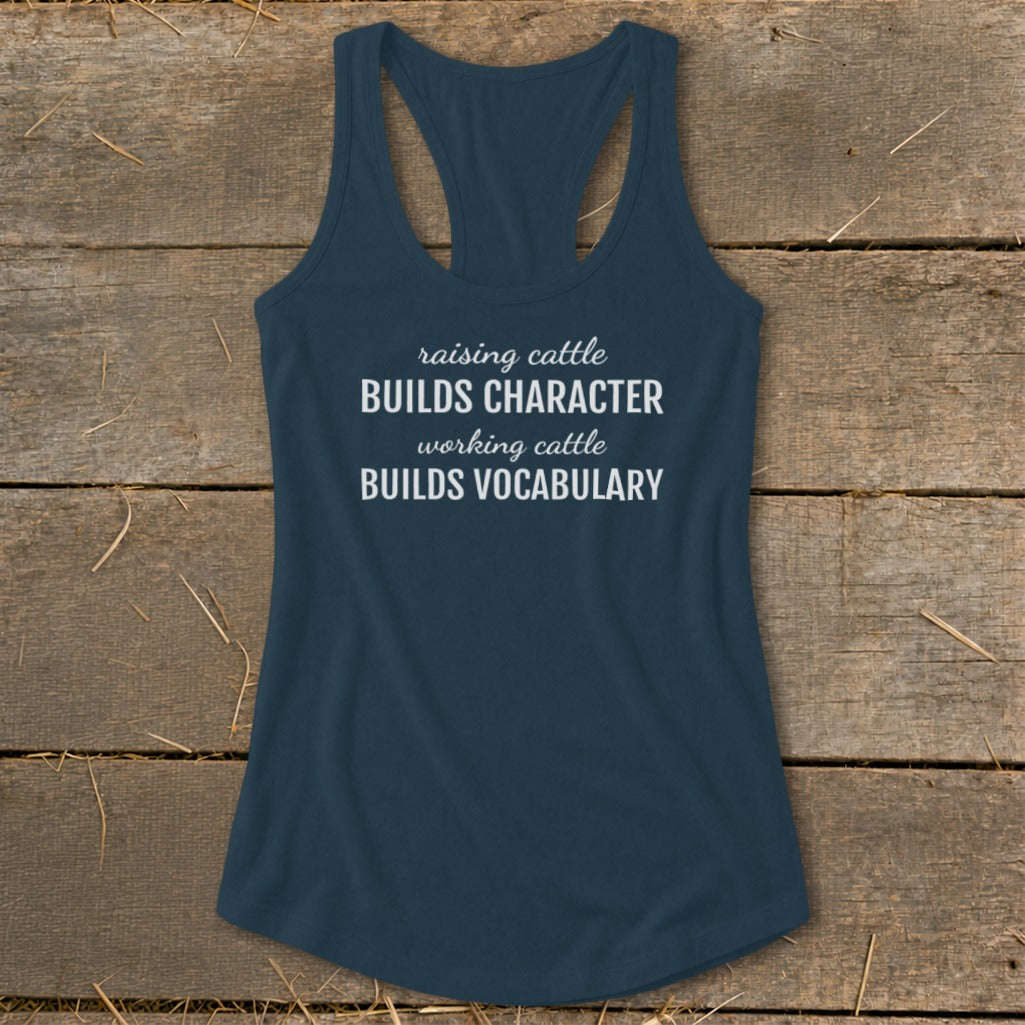 Navy tank top with white text "raising cattle BUILDS CHARACTER working cattle BUILDS VOCABULARY."