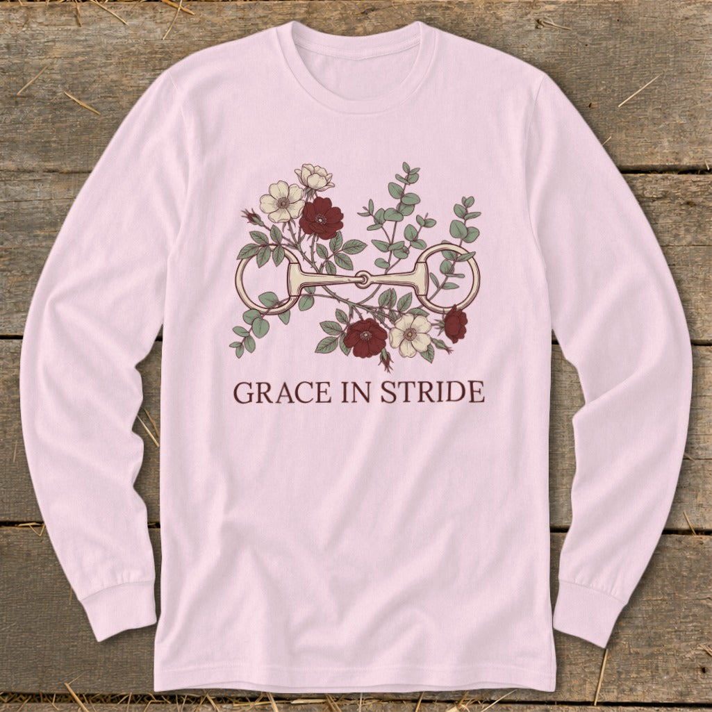 Pink long-sleeve shirt with a horse bit and floral design, reading "GRACE IN STRIDE."