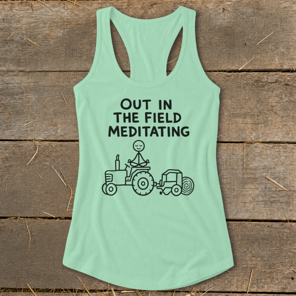Light green tank top with black text and graphic of person meditating on tractor.