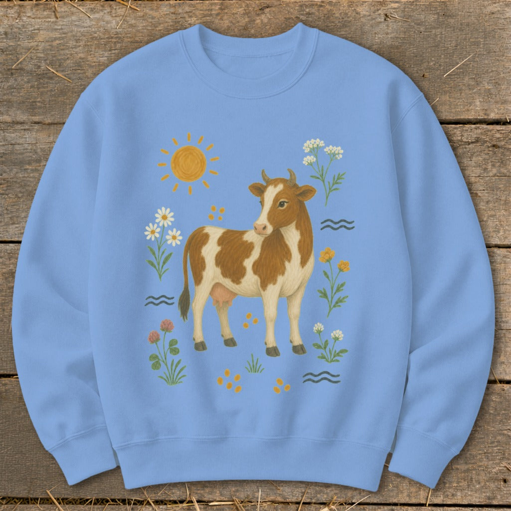 Light blue sweatshirt with a cow, sun, and flowers illustration.