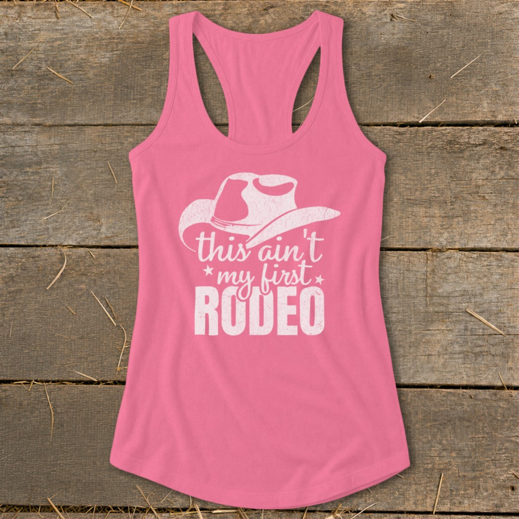 Pink tank top with white cowboy hat and "This ain't my first Rodeo" text.