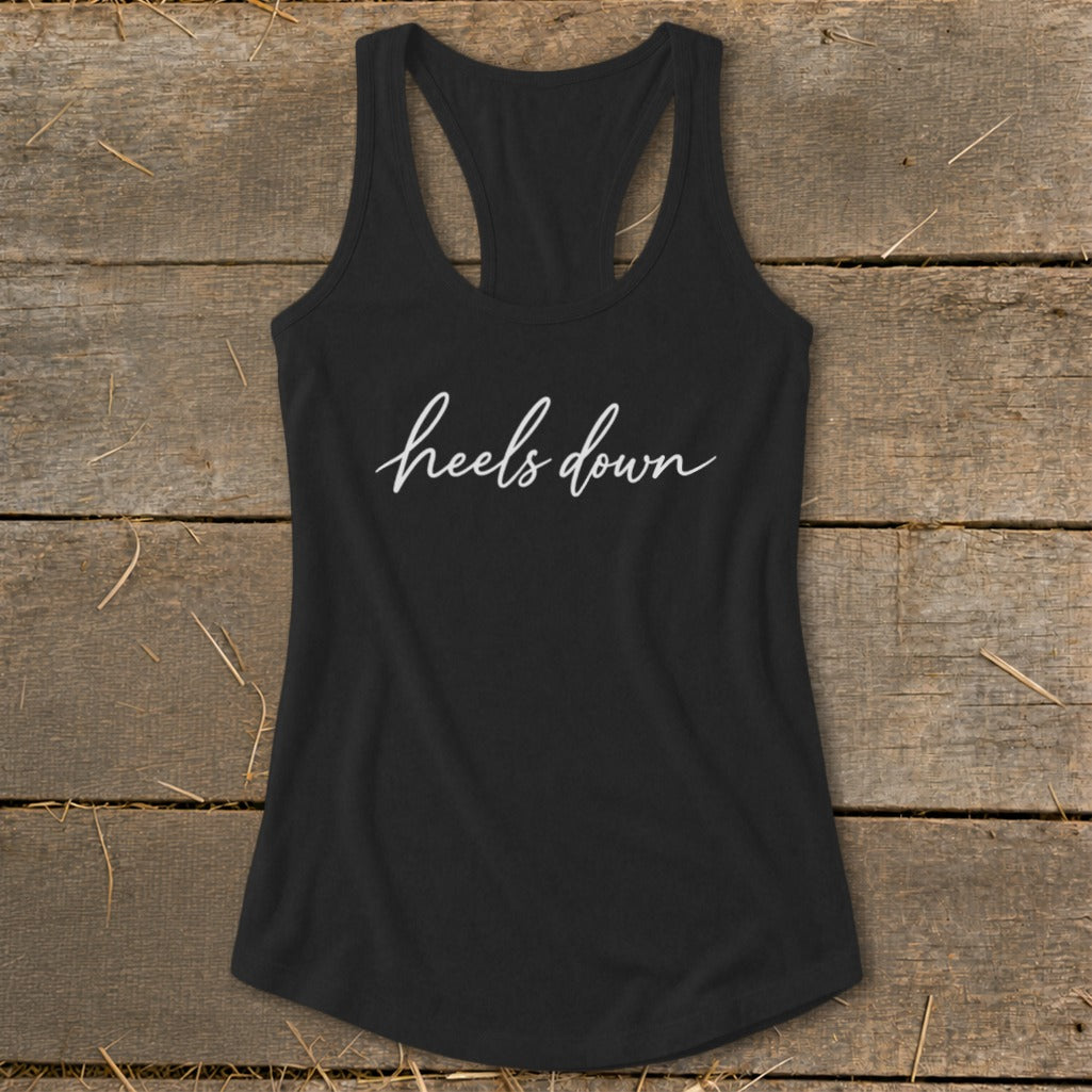 Black racerback tank top with white script text "heels down".