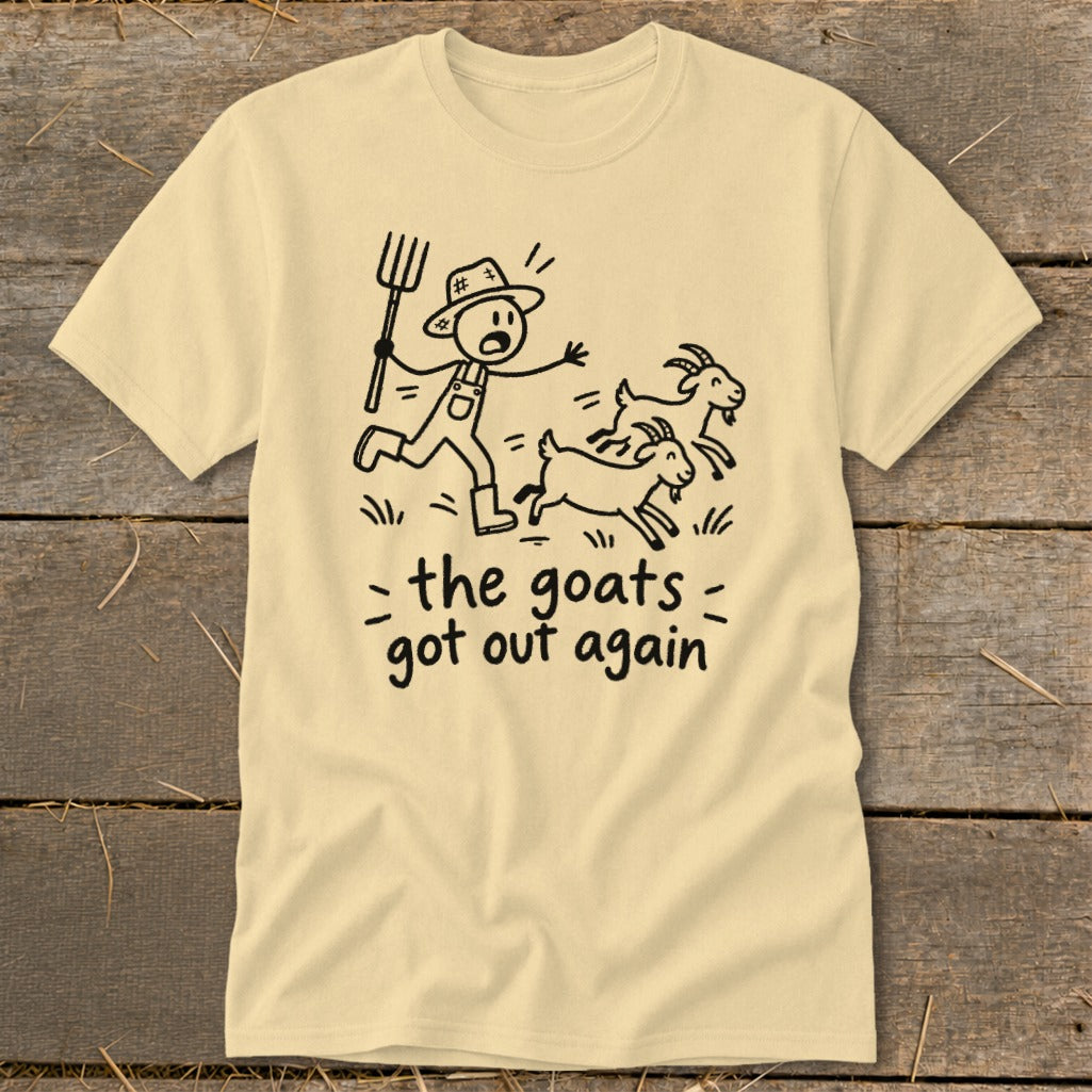 Light yellow t-shirt with a cartoon of a farmer chasing goats and the text "the goats got out again".
