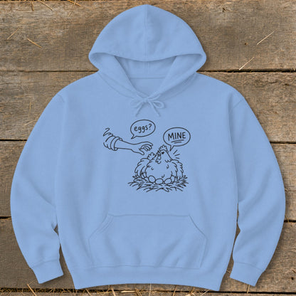 Light blue hoodie with black line art of a chicken protecting its eggs with "MINE" speech bubble.