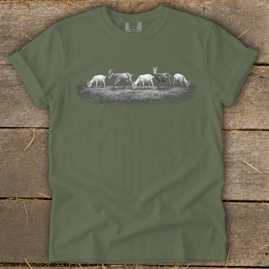 Green t-shirt with a graphic of five goats grazing in a field.