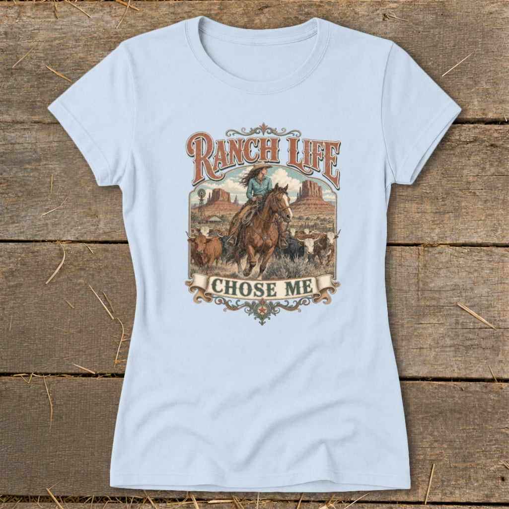 Light blue t-shirt graphic with a cowgirl on horseback, cattle, and "Ranch Life Chose Me" text.
