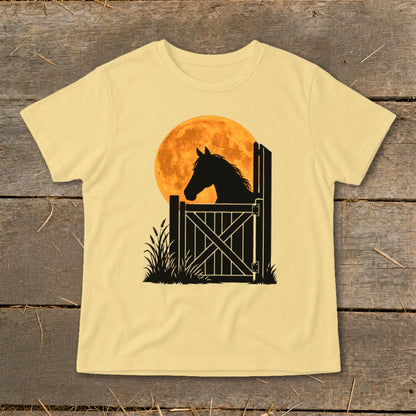 A pale yellow short-sleeved t-shirt featuring a graphic of a horse's silhouette looking over a wooden stable gate against a large orange moon.