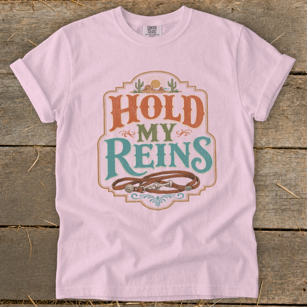 Pink t-shirt with "HOLD MY REINS" graphic and horse bridle.
